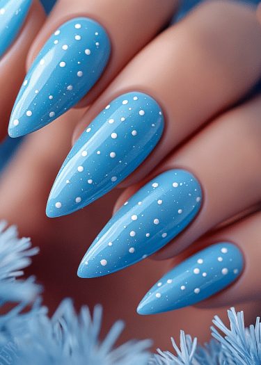 Light blue almond stiletto nails with white polka dots for trendy nail art inspiration.