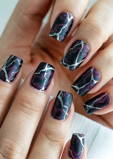 Stunning dark purple and black nail art with intricate lightning designs for creative manicures.