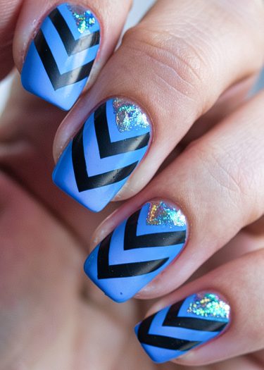 Bright blue chevron nail art with holographic glitter for stylish, modern manicure designs.