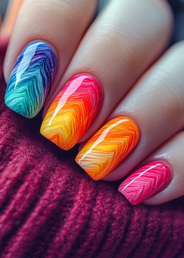 Vibrant gradient nail art with intricate patterns on beautifully polished nails.