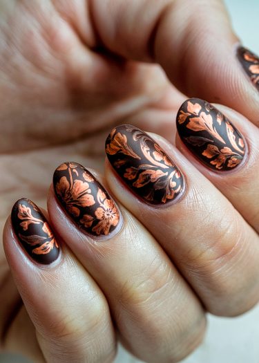 Elegant brown floral nail art design with copper accents on well-maintained almond-shaped nails.