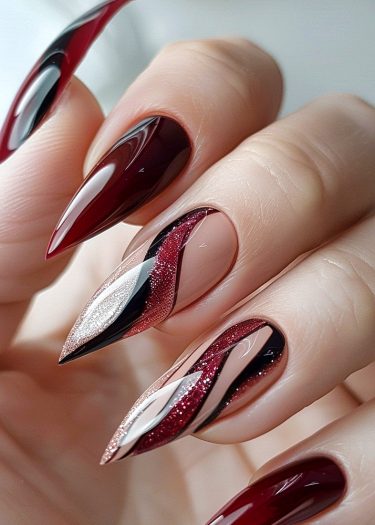 Stunning burgundy, black, and silver stiletto nail art with intricate designs and glossy finish.