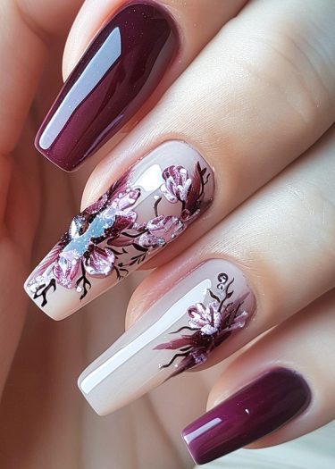 Elegant burgundy and floral nail art design with intricate details and glossy finish.