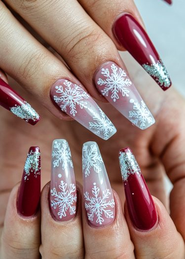 Elegant burgundy snowflake nail art with glitter accents, perfect for winter-themed fashion.