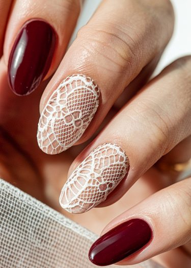 Elegant burgundy lace nail art featuring intricate patterns, perfect for special occasions.