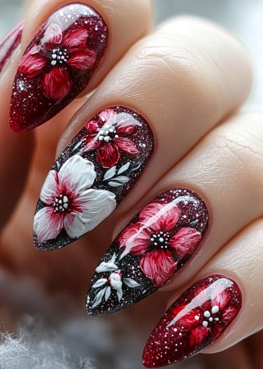 Elegant burgundy stiletto nails with intricate floral designs and shimmering accents.