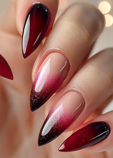 Elegant burgundy ombre stiletto nails with glitter for a luxurious nail art design.