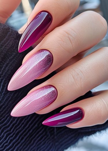 Elegant burgundy to pink gradient stiletto nails with glitter accents, perfect for modern nail art.