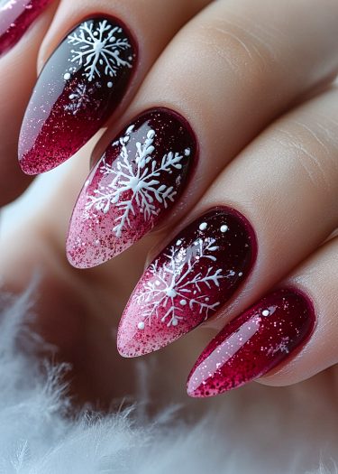 Elegant burgundy-pink ombre nails with intricate winter snowflake designs and glitter accents.