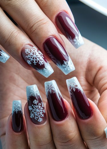 Elegant burgundy coffin nails with snowflake designs, perfect for winter and holiday celebrations.