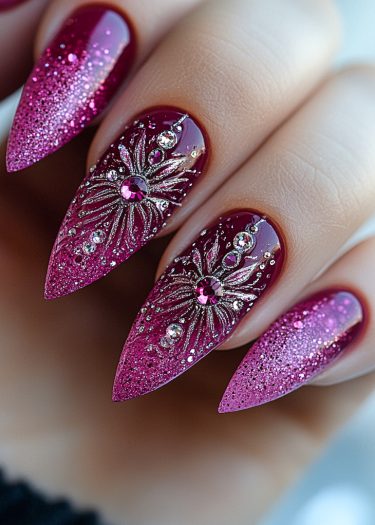 Elegant burgundy stiletto nails with pink and silver rhinestone starburst designs and glitter tips.