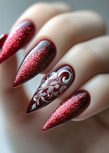 Stunning deep red almond-shaped nails with intricate glitter detailing and elegant design accents.