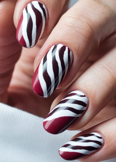 Burgundy zebra nail art with glossy finish for stylish and elegant manicured hands.