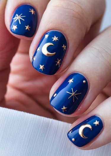 Celestial blue nail art featuring gold moons and stars for an elegant evening look.