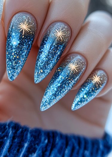 Elegant celestial blue stiletto nails with glitter and star patterns, perfect for a glamorous look.