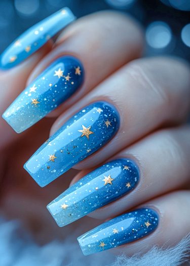 Stunning galaxy-inspired nail art with ombre blue shades and gold stars for a celestial look.