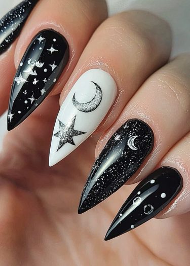 Stunning celestial nail art featuring stars, moons, and planets in a chic black and white design.