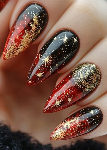 Stunning celestial stiletto nail art with red and black gradient, gold glitter, and star designs.