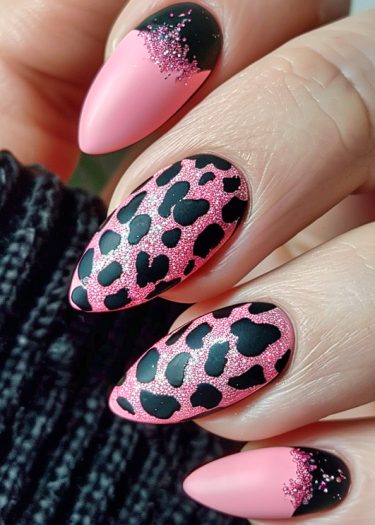 Chic pink and black nail art with leopard print, almond shape, and glitter accents.