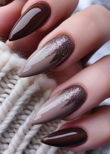 Elegant chocolate and nude nail art with glitter on a textured knit background.