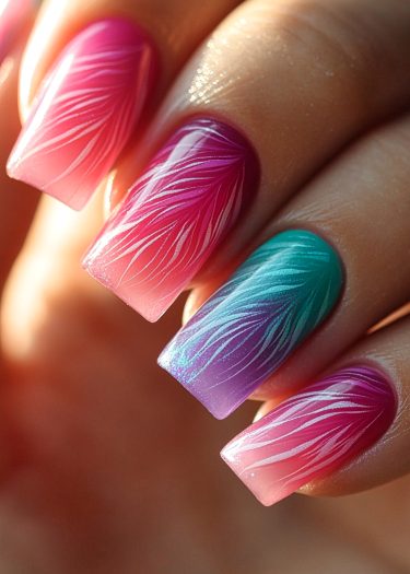 Vibrant ombre nail art featuring intricate designs in pink, magenta, turquoise, and purple.