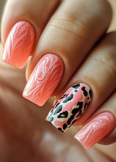 Stylish coral-pink manicure with intricate designs and an animal print accent nail.