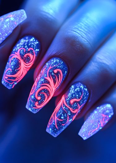 Vibrant cosmic blue nail art with neon pink designs and glittering details for a striking look.