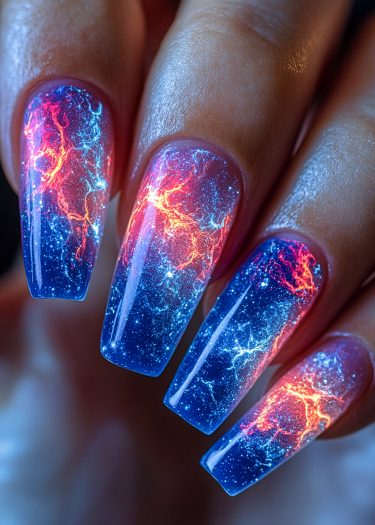 Vibrant galaxy nail art featuring cosmic designs in blues, purples, reds, and sparkling stars.