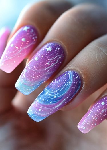 Cosmic nail art features galaxy-inspired designs with vibrant gradient colors and sparkling stars.