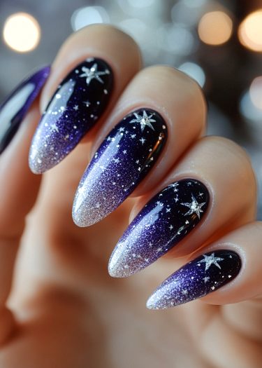 Elegant cosmic nail art featuring a gradient blue design with shimmering stars.