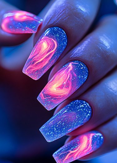 Vibrant cosmic nail art featuring neon pink and blue swirls with glittery accents.