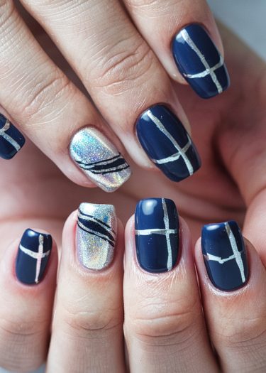 Elegant dark blue nail art with silver geometric designs and holographic accents.