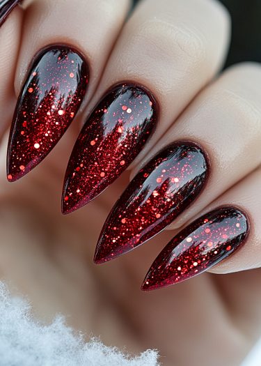 Glamorous stiletto nails with shimmering red and dark glitter create a stunning fashion statement.