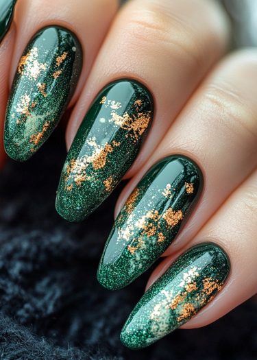 Elegant dark green almond nails with shimmering gold foil art for a luxurious look.