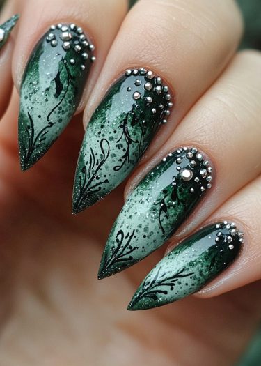 Elegant green stiletto nails with intricate floral designs and metallic accents for a sophisticated look.