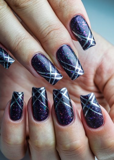 Elegant black glitter nails with silver geometric designs for a glamorous manicure look.