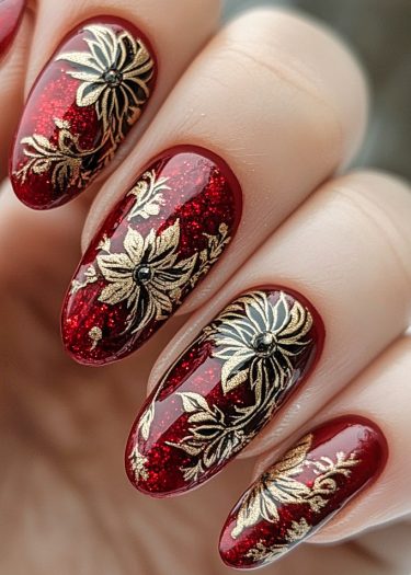 Elegant dark red and gold floral nail art with intricate designs and shimmering accents.