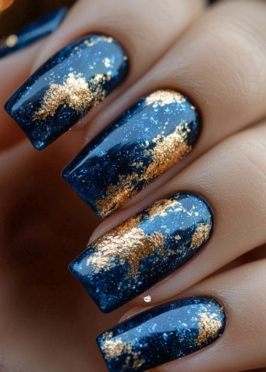 Exquisite navy blue and gold foil nail art with long square tips for elegant style.