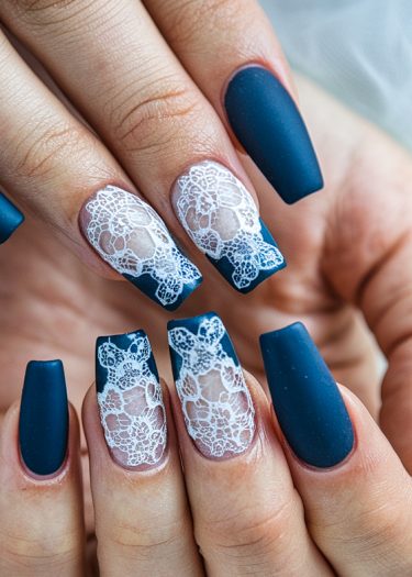 Elegant deep blue coffin nails with intricate white lace designs for stunning nail art.