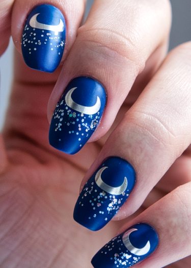 Elegant deep blue matte nail art with silver crescent moons and glittering stars.