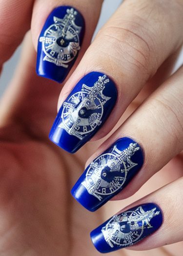 Elegant royal blue and silver nail art featuring intricate designs and stylish craftsmanship.