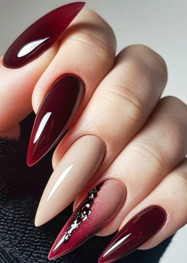 Elegant stiletto nails in deep burgundy and nude beige with stunning rhinestone accents.