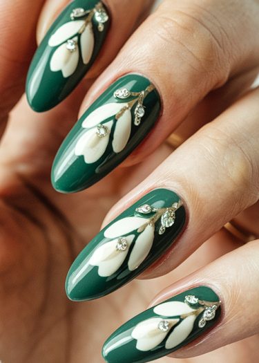 Elegant deep green nail art with floral designs and sparkling rhinestones for a luxurious look.