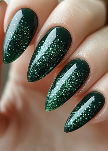 Elegant deep green glitter nails in a glossy almond shape, showcasing a stunning starlit effect.