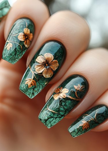 Elegant deep green nails with gold floral designs, perfect for sophisticated styles and special occasions.