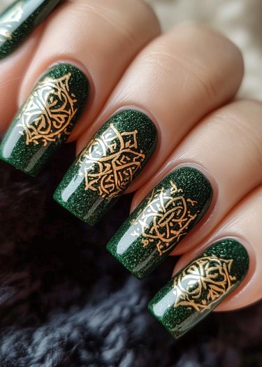 Elegant deep green nail art with shimmering gold designs for a sophisticated look.