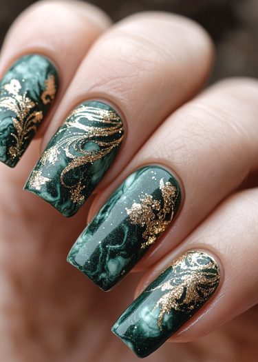 Luxurious jade green and gold nail art featuring intricate marbling and elegant embellishments.