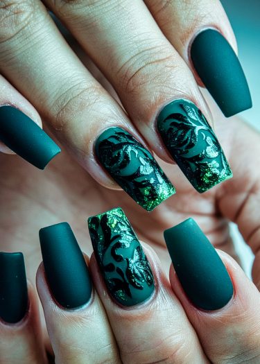 Sophisticated matte teal acrylic nails with intricate black designs and reflective green accents.