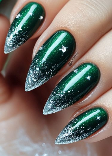 Glamorous stiletto nails in emerald green with silver glitter and star designs for a chic look.