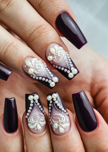 Elegant deep purple coffin nails with intricate lace design and pearl embellishments.